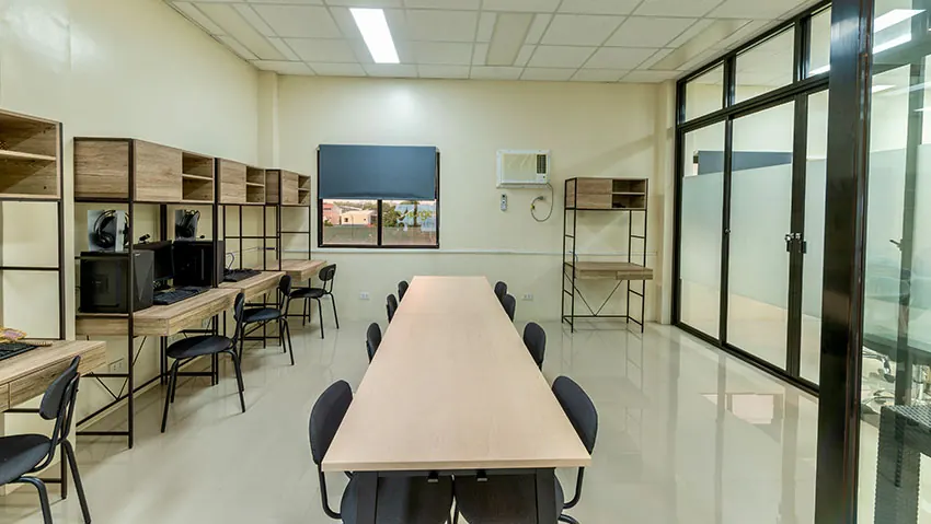Long shared work table by glass partitions